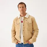 Campera Wrangler de pana color beige con cuello de piel sintética color crema, cierre frontal con botones metálicos, bolsillos con solapa abotonada en el pecho y bolsillos laterales.