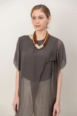 Maxi blusón negro de seda con diseño asimétrico en picos y mangas cortas fluidas.