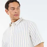Camisa de manga corta con diseño de rayas verticales azules sobre fondo blanco, cuello camisero, cierre frontal con botones y bolsillo aplicado en el pecho.