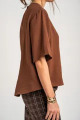 Blusa de manga corta color marrón, con escote redondo y diseño holgado.