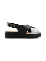 Sandalia de plataforma con tiras cruzadas en cuero negro y plateado, con ajuste de hebilla metálica lateral y suela de poliuretano.