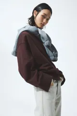 Buzo oversized de algodón color bordó, con cuello redondo y hombros caídos.