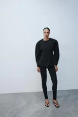 Leggings negros de tiro alto con bolsillos falsos de vivo en el delantero y cierre lateral con cremallera oculta. Presentan cremalleras ocultas en los bajos.