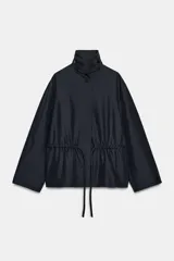 Parka de cuello alto con trabilla y manga larga, color azul marino. Presenta bolsillos laterales ocultos en la costura y cintura ajustable con cordón. El cierre frontal es con botones ocultos por solapa.