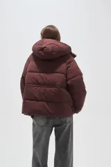 Campera puffer de corte holgado, color beige, con capucha desmontable, cierre frontal y puños elásticos.