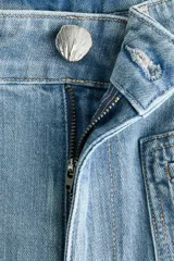 Pantalón jean de denim de algodón con leve stretch, tiro alto y pierna ancha. Cuenta con bolsillos tipo parche en el frente y raya marcada en ambas piernas.