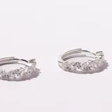 Aros tipo argolla de plata enchapada, engarzados con piedras de circonia transparentes en forma de pera y redondas.