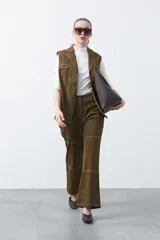 Pantalón de corte recto y tiro medio, confeccionado en algodón con elastano. Presenta costuras a contratono en color blanco que resaltan los recortes delanteros y el diseño de la prenda, aportando un estilo utilitario.