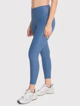 Calza deportiva de tiro alto con cintura en forma de V, confeccionada en tela brillante de efecto segunda piel. Presenta un diseño liso y ajuste regular.