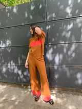 Sweater marrón de tejido de punto con una franja horizontal roja en el pecho y mangas cortas abullonadas.