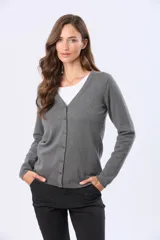 Saco tejido fino de hilo de algodón color beige, con cuello en V, cierre frontal con botones y puños acanalados.