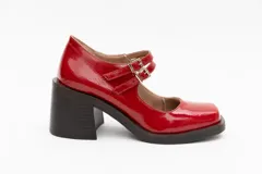 Guillerminas de cuero charol negro con punta cuadrada, taco ancho y correa sobre el empeine con doble hebilla dorada.