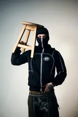 Campera hoodie negra con cierre frontal, bolsillos tipo canguro, capucha con cordón ajustable y detalles de ribete blanco. Presenta un logo con un globo terráqueo y el número 27 en el pecho y un estampado de una estrella con incrustaciones en la espalda.