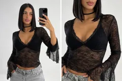 Blusa de encaje negro con diseño ajustado, escote en V profundo y mangas largas acampanadas. Presenta un diseño con copas integradas y textura floral.