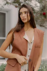 Chaleco sastrero de lino marrón con diseño a rayas y bolsillos frontales con solapa.