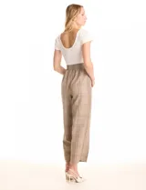 Enterito combinado de la marca Love & Piece. La parte superior es una remera blanca de manga corta y escote redondo. La parte inferior es un pantalón estampado a cuadros en tonos beige y marrón, con cintura elastizada y bolsillos inclinados en la delantera.