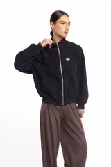 Campera negra de cuello alto con cierre frontal metálico completo, bolsillos laterales y logo bordado en el pecho.