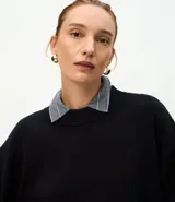 Buzo de tricot con cuello redondo y puños ajustados. Presenta un diseño de calce holgado y tejido de punto liso.