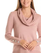 Buzo de tejido fino con lurex color rosa, con cuello volcado texturizado y mangas largas con apliques de brillos en los puños. Presenta un bajo recto con terminación en rib y tajos laterales.