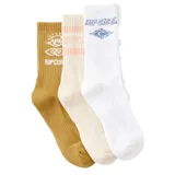 Pack de tres pares de medias deportivas Rip Curl de caña media, con diseños estampados: un par color ocre con logo y diseño de sol, un par color crema con rayas horizontales rosas y logo, y un par blanco con logo y diseño geométrico en azul.