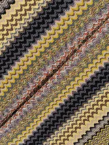 Capa o poncho de tejido de punto con diseño de zigzag multicolor, con cuello en V y flecos largos en el borde inferior.