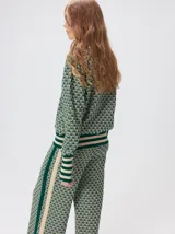 Sweater de tejido de punto jacquard con diseño geométrico, cuello redondo y puños acanalados en contraste de color verde y beige.