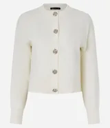 Cardigan de punto color negro, con cuello redondo, mangas largas y cierre frontal mediante botones metálicos con diseño de flores. Presenta puños y ruedo acanalados.