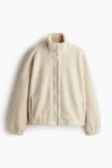 Campera de sherpa con cuello alto, hombros caídos, cierre frontal oculto con botones a presión y bolsillos laterales insertados. Diseño forrado con puños elásticos.