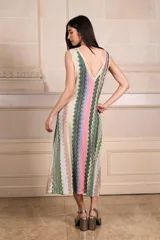 Vestido largo de tejido de punto con estampado de zig-zag vertical en tonos rosados, verdes, beige y lila. Presenta escote en V pronunciado tanto en el frente como en la espalda, con vivos de punto con lurex.