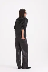 Pantalon de corte recto y holgado, confeccionado en material engomado de acabado satinado en color negro.