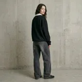 Jean de corte holgado y tiro alto, con diseño de pierna ancha y acabado lavado en tono gris oscuro. Presenta costuras reforzadas y estilo urbano.