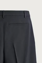Pantalón relaxed fit azul marino confeccionado en tejido con lana, con bolsillos frontales, bolsillos traseros de doble vivo y pliegues en la parte delantera.