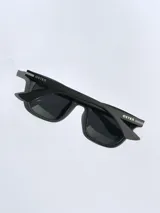 Lentes de sol con armazón de color gris mate y detalles en azul en las patillas. Cuentan con cristales oscuros polarizados y protección UV 400.