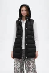 Chaleco acolchado negro con capucha ajustable mediante cordones, cierre frontal con botones a presión y bolsillos laterales con cierre.