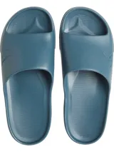 Ojotas tipo slide de color azul verdoso, con una banda ancha superior que presenta el logo 'CK' en relieve. La plantilla tiene textura acanalada para mayor agarre.