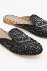 Zuecos negros con bordados dorados y canutillos. Taco de madera de 1,5 cm y forro interior de gamuza.