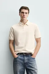 Polo de corte regular fit en tejido de algodón con estructura vertical color beige. Presenta cuello solapa, cierre frontal de botonadura y manga corta con rib.