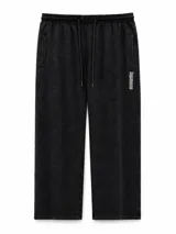 Pantalón de estilo urbano en color negro con efecto lavado, corte recto y holgado. Cuenta con cintura elástica con cordón ajustable, bolsillos laterales y un detalle de texto estampado en vertical sobre uno de los bolsillos.
