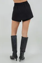 Mini short negro con sobre falda y detalles de brillo sutil.