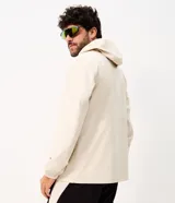 Campera deportiva masculina Get Over con capucha ajustable, cierre frontal completo, bolsillos laterales y recortes horizontales, confeccionada en poliéster tecnológico de color beige.