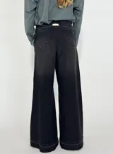 Pantalón jean negro de corte ancho con cintura alta elastizada y cordón de ajuste.