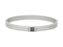 Pulsera rígida de acero plateado con tres líneas paralelas y detalle central de dos circonias negras cuadradas separadas por pequeños cristales blancos.
