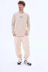 Pantalón cargo de gabardina color negro, con bolsillos laterales tipo cargo, cintura elástica con cordón ajustable y puños elásticos en los tobillos.