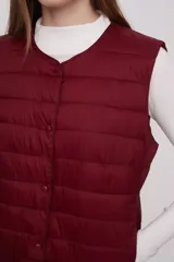 Chaleco acolchado color verde militar con cierre de botones a presión.