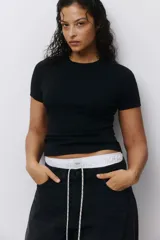 Remera básica de algodón negro, de corte entallado, cuello redondo y mangas cortas.