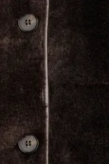 Abrigo de textura afelpada en color marrón oscuro, con cuello, ribetes y detalles en cuero sintético. Presenta un corte holgado, cierre frontal con botones, mangas raglán y bolsillos laterales.