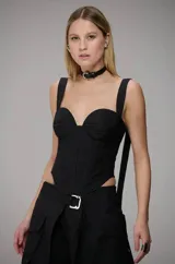 Corselet negro de estilo estructurado con escote corazón, tirantes anchos y diseño entallado que realza la silueta. Presenta costuras verticales que definen su forma y un acabado minimalista.