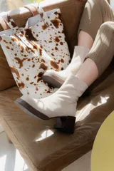 Botas de caña corta en gamuza color beige, con plataforma y taco cuadrado de madera oscura. Presentan cierre lateral interno.
