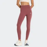 Calza deportiva New Balance Sleek High Rise, color rojo oscuro o rosado quemado, de tiro alto y corte ajustado. Presenta el logo NB reflectante en la parte trasera del muslo.