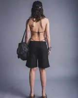 Bermuda negra de tela rústica con elástico en la cintura y estampado con la palabra "Finnesse" en letras blancas.